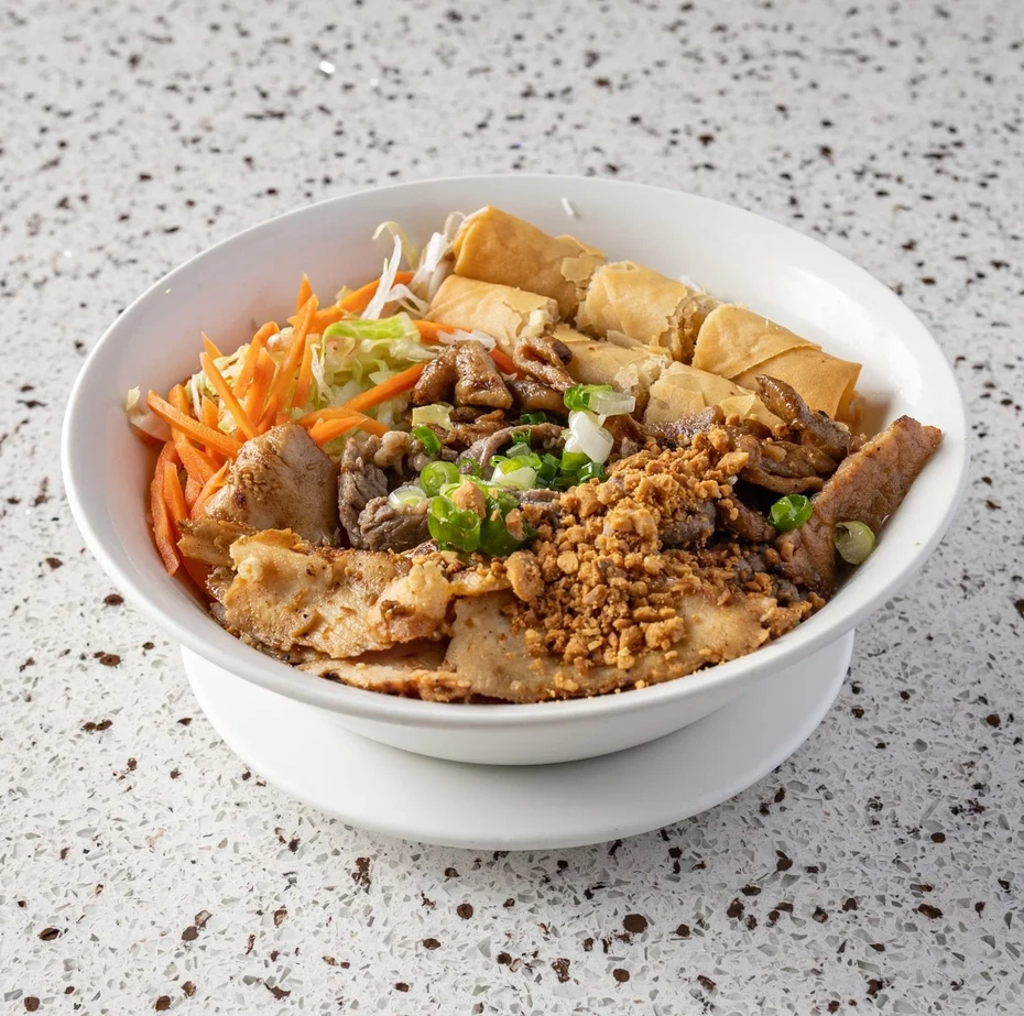 Charbroiled beef, chicken and pork with spring rolls on vermicelli at Saigon Royal Calgary